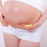 Pregnant woman holding pills